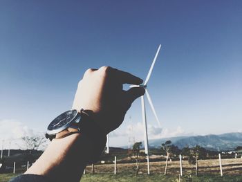 Optical illusion of man holding wind turbine