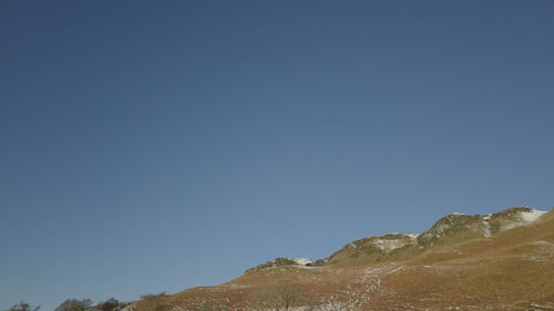 Low angle view of mountain against clear blue sky