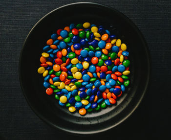 Directly above shot of multi colored candies in bowl on table