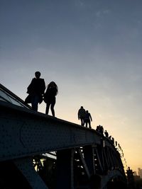 Low angle view of men working against sky