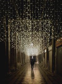 Silhouette of man on illuminated street at night