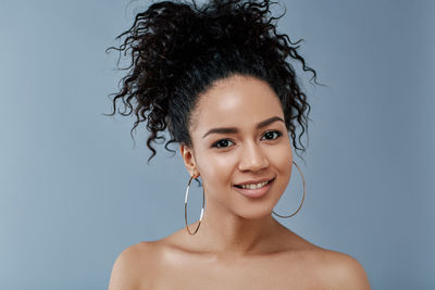 Close-up of young woman against blue background