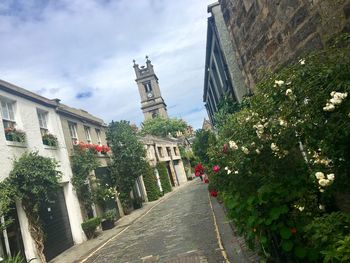 Footpath amidst buildings against sky