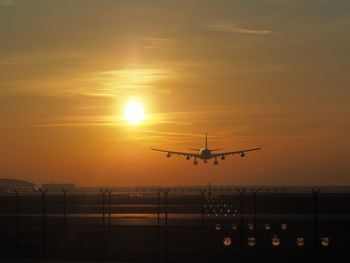 Airplane flying in sky during sunset