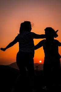 Silhouette people against sky during sunset