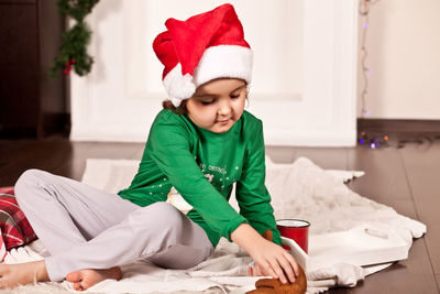 Cute baby girl sitting on sofa at home