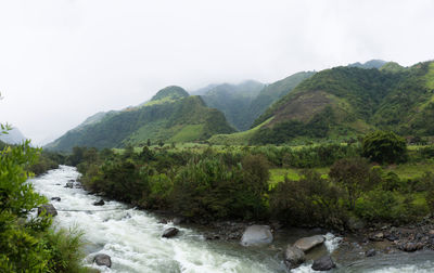 Scenic view of river amidst mountains against sky