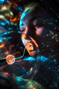 Digital composite image of woman and plasma ball with fiber optics