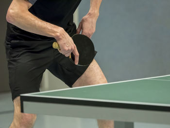 Midsection of man playing table tennis 