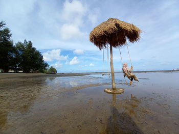 Coconut palm trees on beach against sky