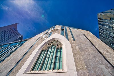 Low angle view of modern building against blue sky