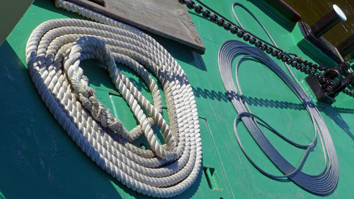 Tilt shot of rolled rope and steel cable on boat deck