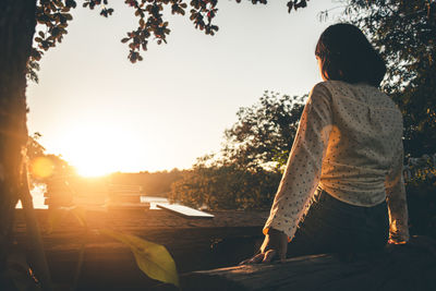 Rear view of man standing against sky during sunset