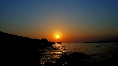 Scenic view of sea against clear sky during sunset