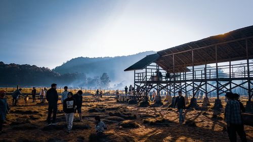 People standing on field against mountain range