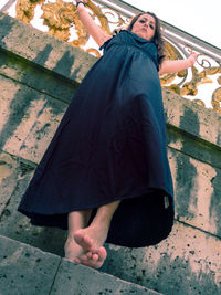 High angle portrait of woman standing on sidewalk