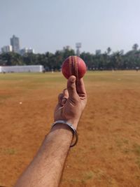 Person holding cricket ball.