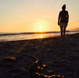 Full length of man standing on beach during sunset