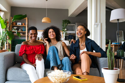 Portrait of smiling friends sitting at home