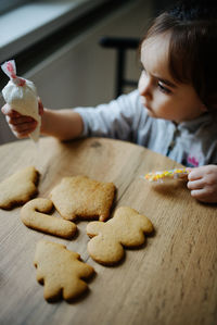 Midsection of woman with cookies on table