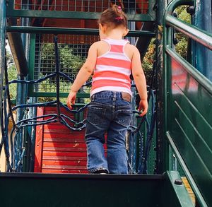 Rear view of girl standing against railing