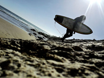 Low angle view of woman walking at beach against clear sky