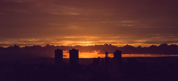 Silhouette buildings against sky during sunset