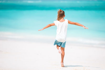 Rear view of girl standing on beach