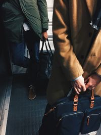 People holding bag while standing on floor