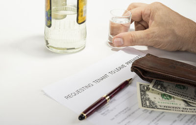 Midsection of man holding drink with table