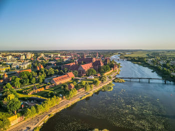 High angle view of river amidst buildings against clear sky