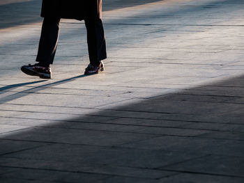 Low section of man walking on footpath