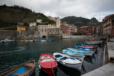 Boats moored on canal by buildings in town