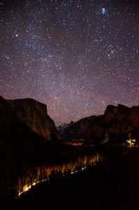 Scenic view of illuminated mountains against sky at night