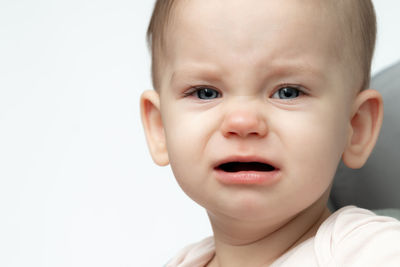 Close-up of cute baby boy against white background