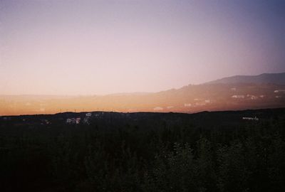 Scenic view of silhouette mountains against clear sky during sunset