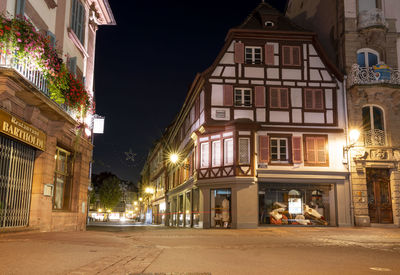 Low angle view of illuminated buildings against sky at night