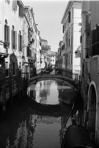 Canal amidst buildings in city against sky