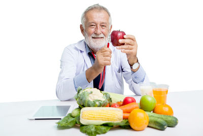 Man holding fruits against white background