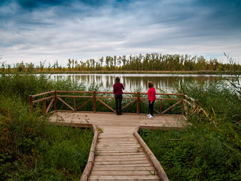 Wooden pier over lake against sky