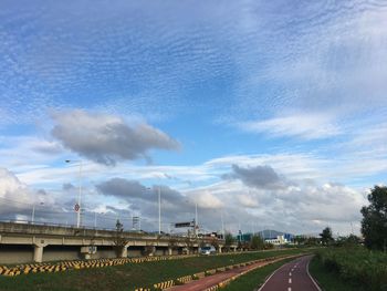 Road by bridge against sky in city