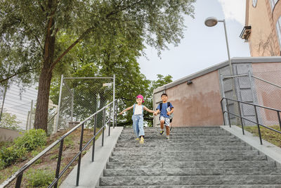 Children holding hands and walking down stairs