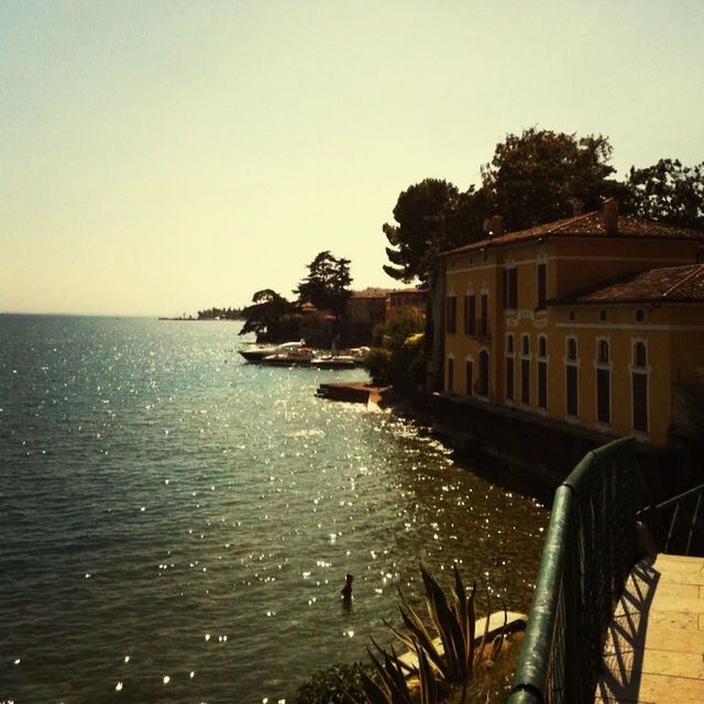 water, sea, clear sky, built structure, architecture, building exterior, horizon over water, copy space, tranquil scene, nature, scenics, tranquility, sky, tree, beach, beauty in nature, house, railing, outdoors, coastline