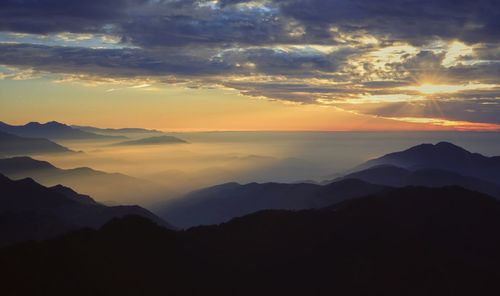 Scenic view of silhouette mountains against sky during sunset