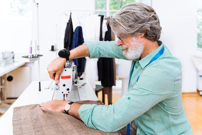 Side view of fashion designer working at studio