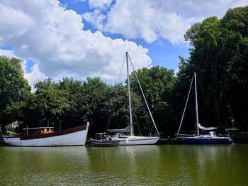 Sailboats moored on lake against sky