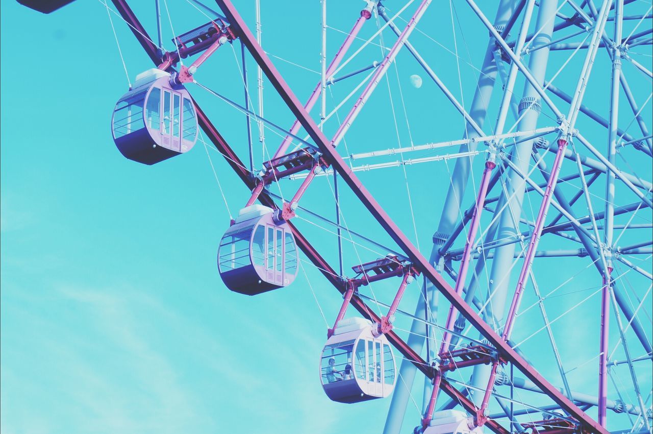 low angle view, blue, amusement park, amusement park ride, ferris wheel, clear sky, arts culture and entertainment, sky, fun, day, outdoors, enjoyment, metal, no people, part of, rope, sunlight, directly below, multi colored, chain swing ride