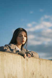 Low angle view of girl looking away against sky. took at rooftop. sunset light. golden hours.
