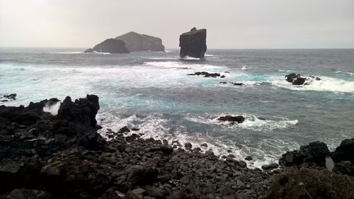 Scenic view of sea and rock formation during foggy weather