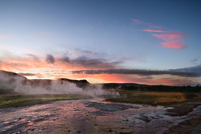 Smoke emitting from geyser against sky during sunset